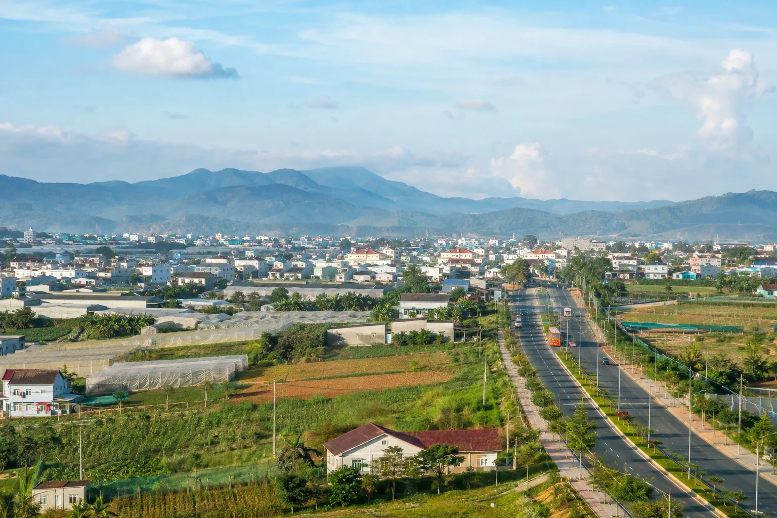 Đô thị thấp, ruộng vườn và trục đường rộng giữa các dãy đồi cao nguyên